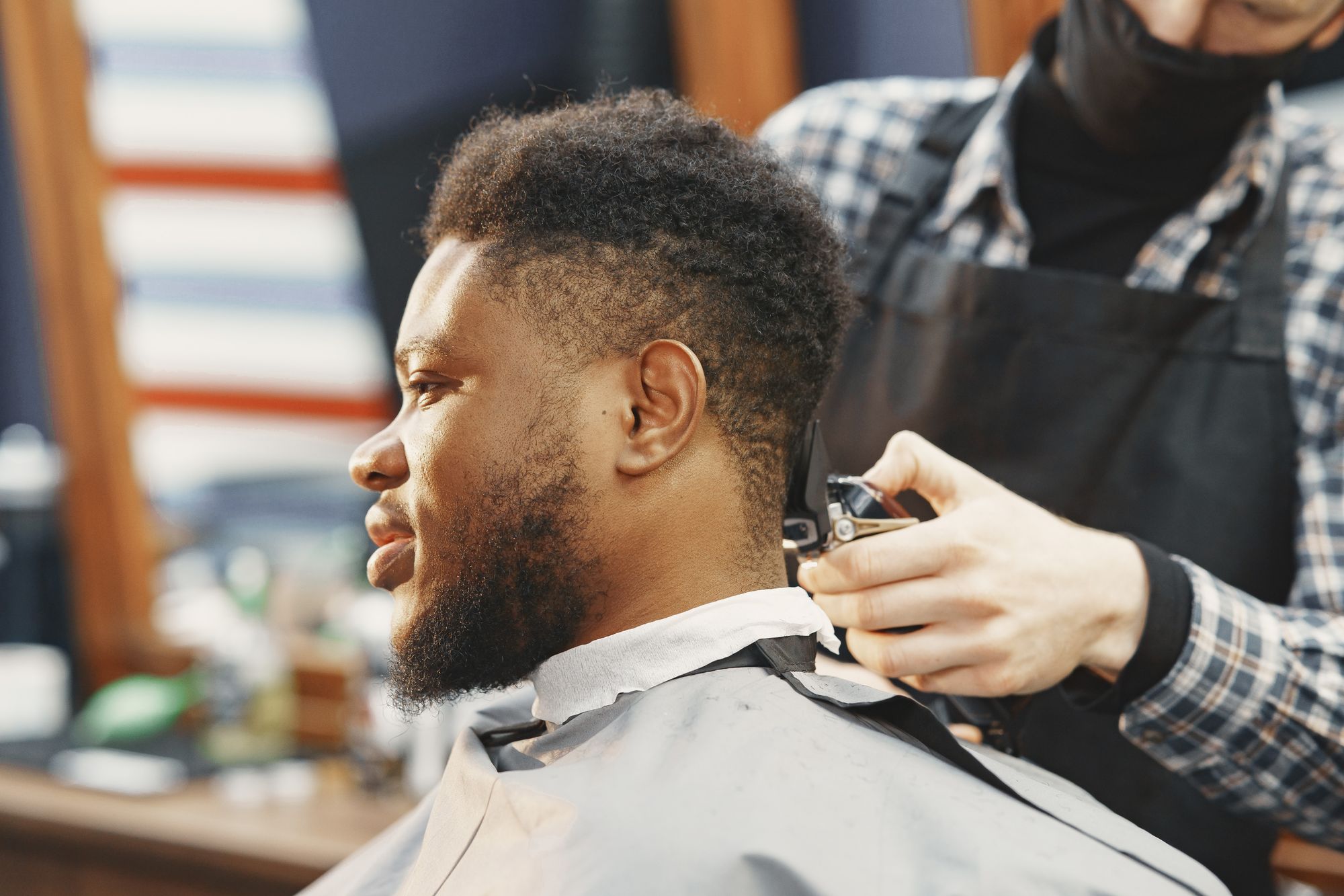 A barber carefully shaping a client's haircut